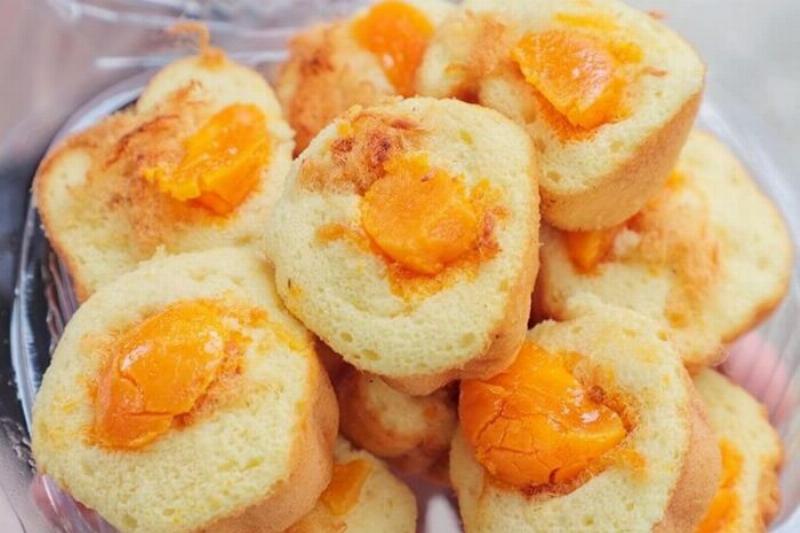Người đang thưởng thức bánh bông lan trứng muối Vũng Tàu cùng trà nóng