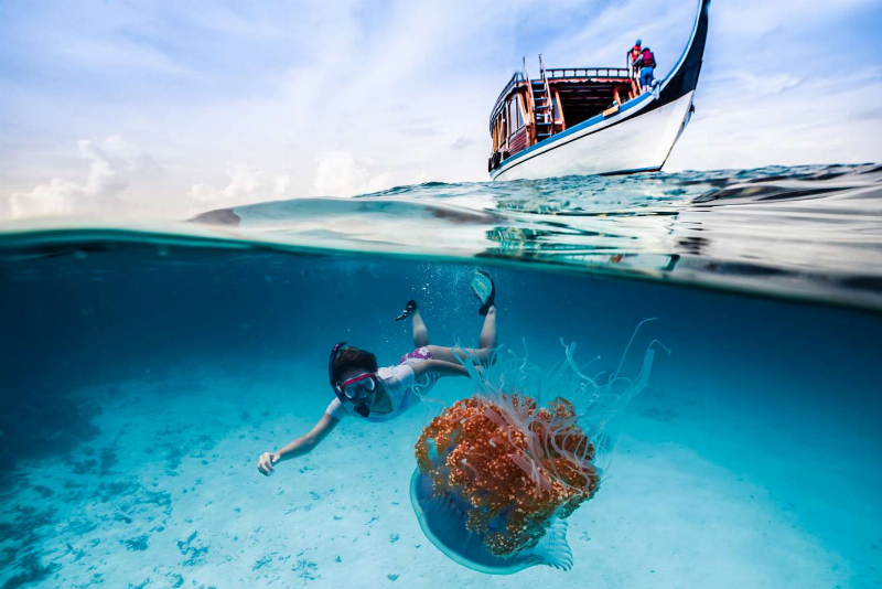 Ngắm hoàng hôn lãng mạn trên biển khi du lịch Maldives, với bầu trời đầy màu sắc và khung cảnh yên bình.