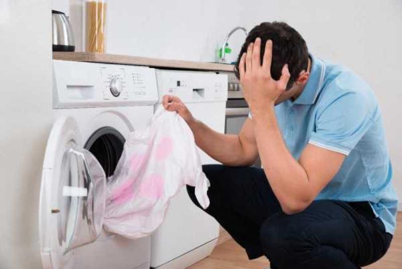 Người đang giặt tay áo Tây Ban Nha màu đỏ trong chậu với nước và xà phòng nhẹ